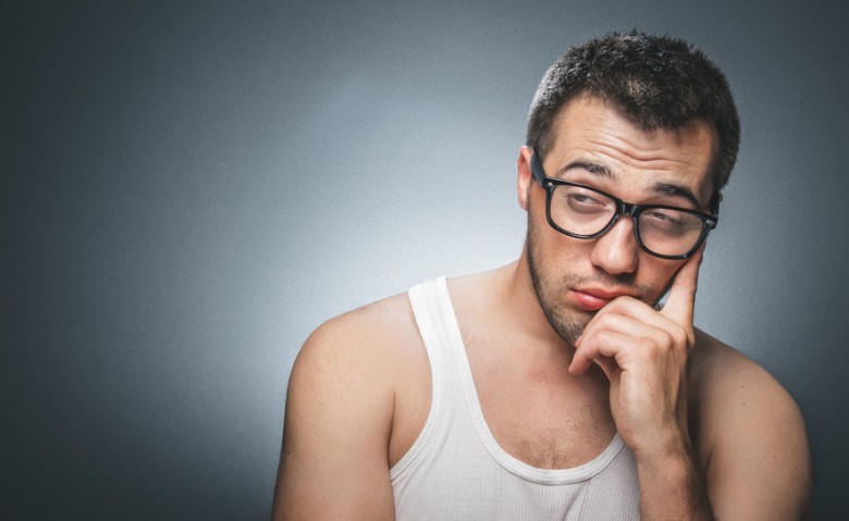 Lazy man against gray background.
Close up of a tired guy.